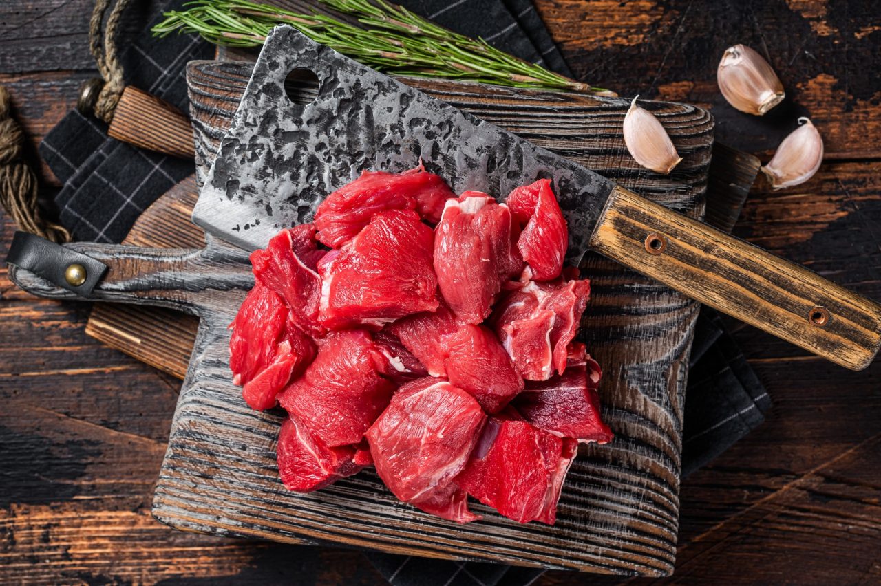 Raw Chopped beef veal meat on butcher board. Wooden background. Top view